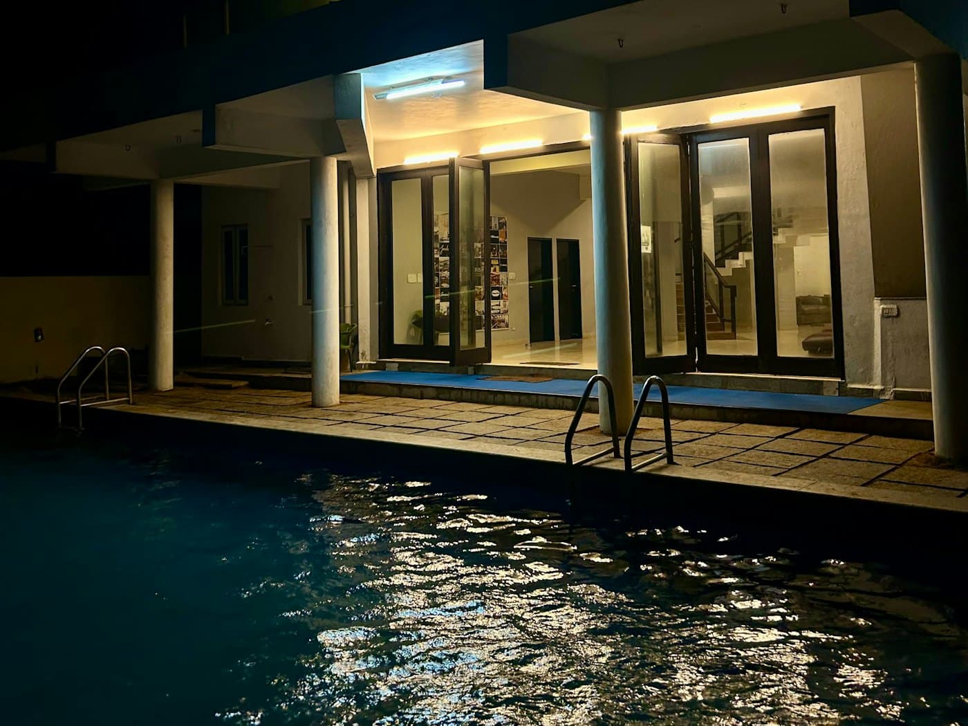 Villa moderne et piscine illuminée à la tombée de la nuit