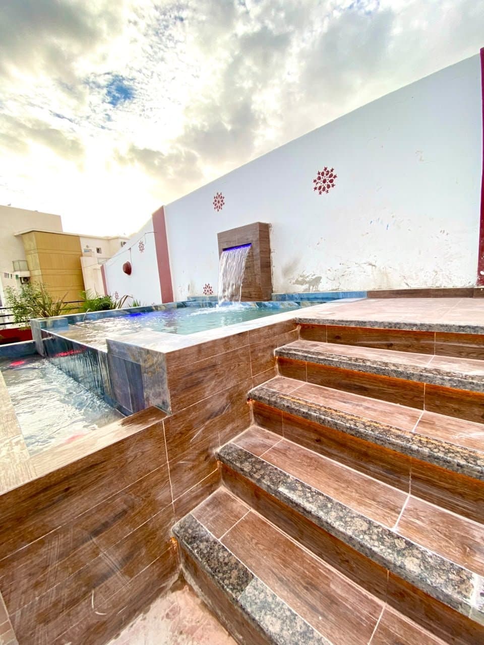 Piscine surélevée sur toit-terrasse avec lame d'eau éclairée et escalier habillé à LED, réalisation RiverPool